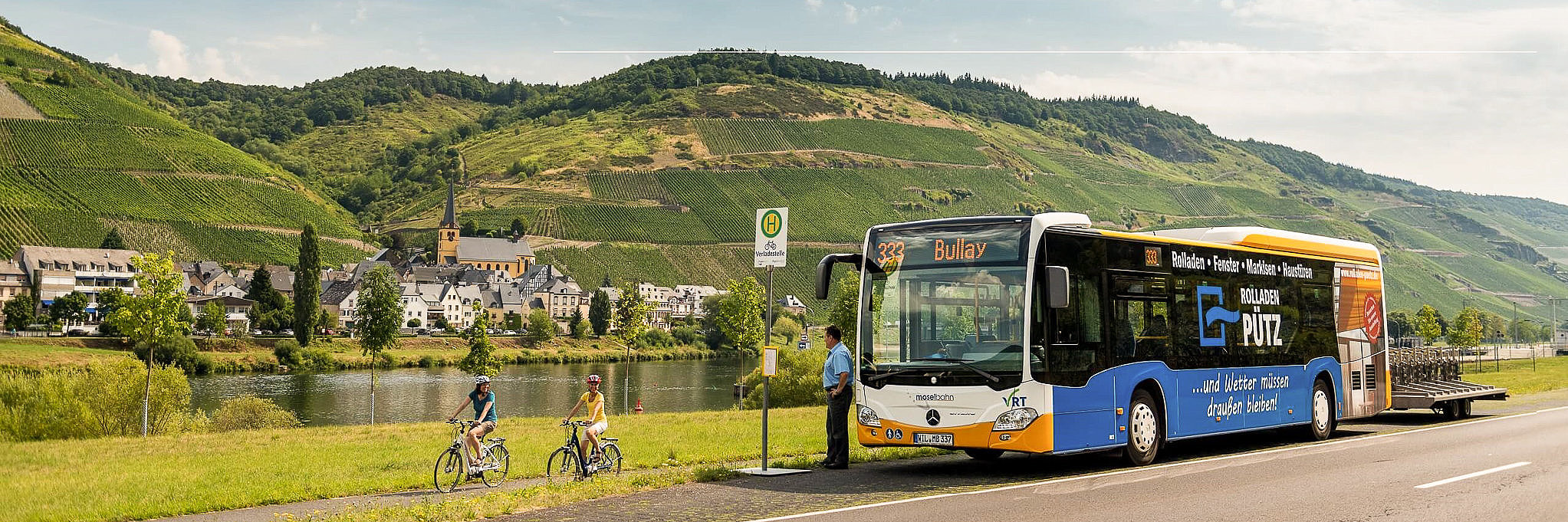 Busfahren an der Mosel Ansicht auf einen Bus am Moselufer und Fahrradfahrer, die sich mit dem Busfahrer unterhalten.