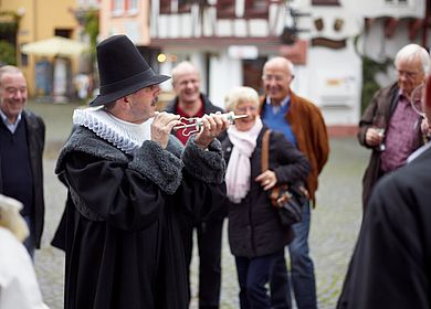 Gästeführer der Doctor-Wein-Tour in Bernkastel-Kues hält Equipment (Spritze) in den Händen. 