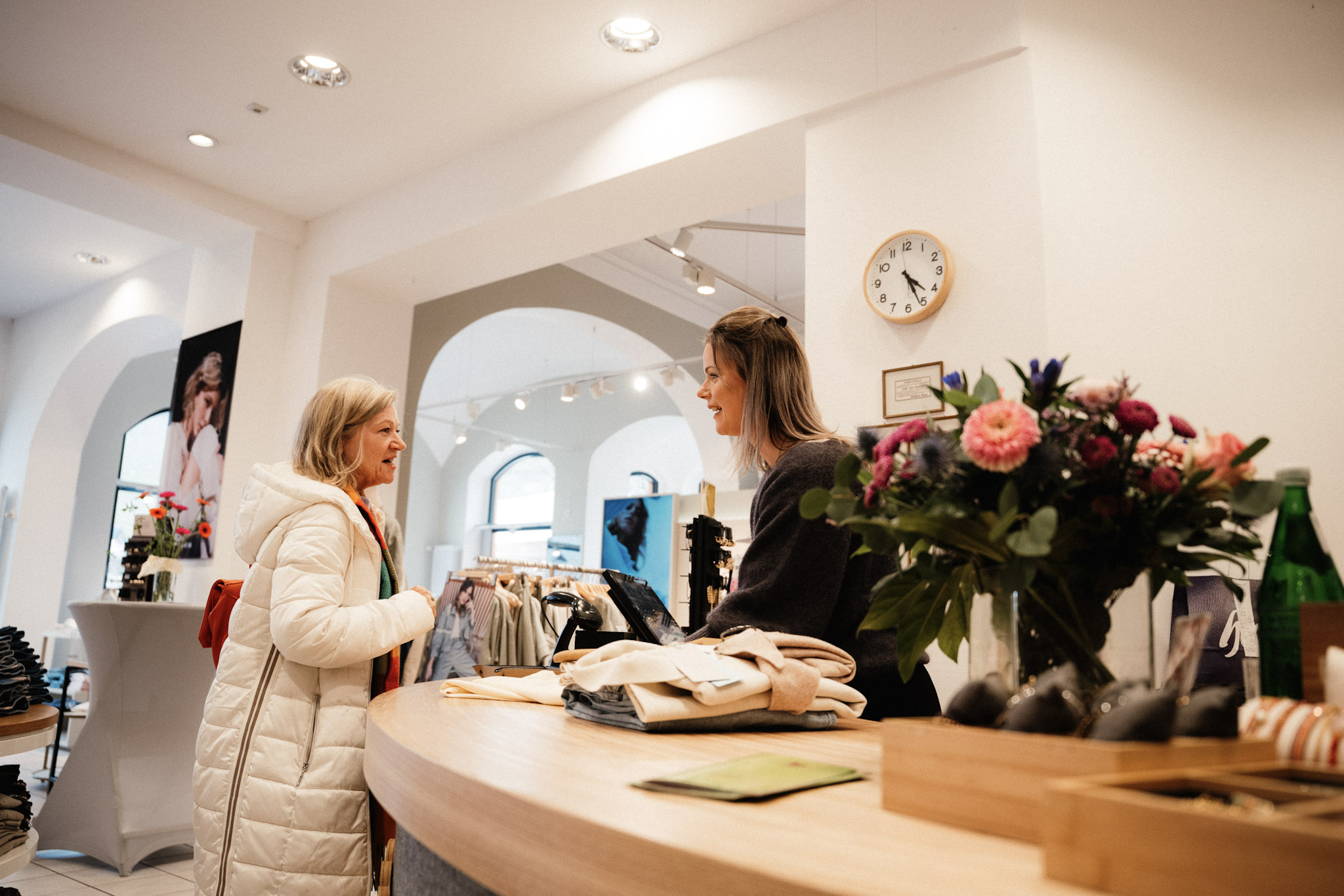 Shoppen in Bernkastel-Kues Eine Frau bezahlt im Bekleidungsgeschäft ihren Einkauf und ist im Gespräch mit der Verkäuferin.